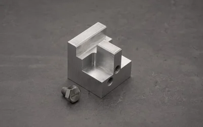 Servicios de fresado CNC produciendo un componente mecanizado de aluminio de precisión con orificios roscados y geometría personalizada